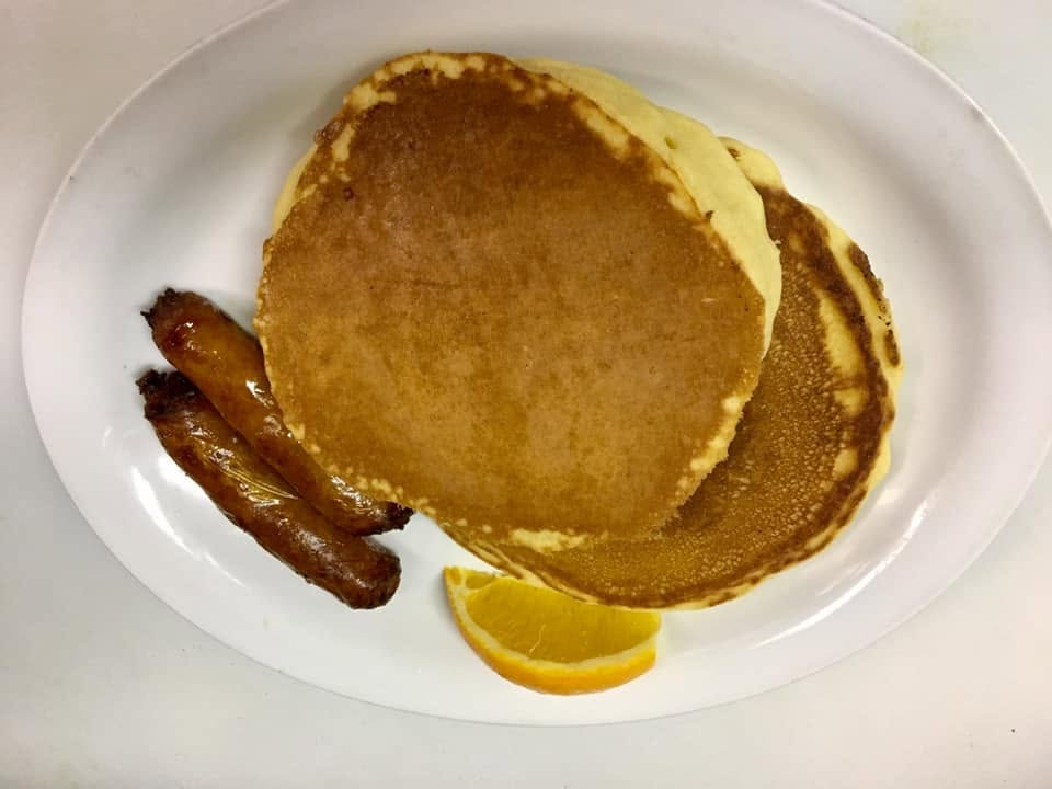 Fluffy golden pancakes served with breakfast sausages