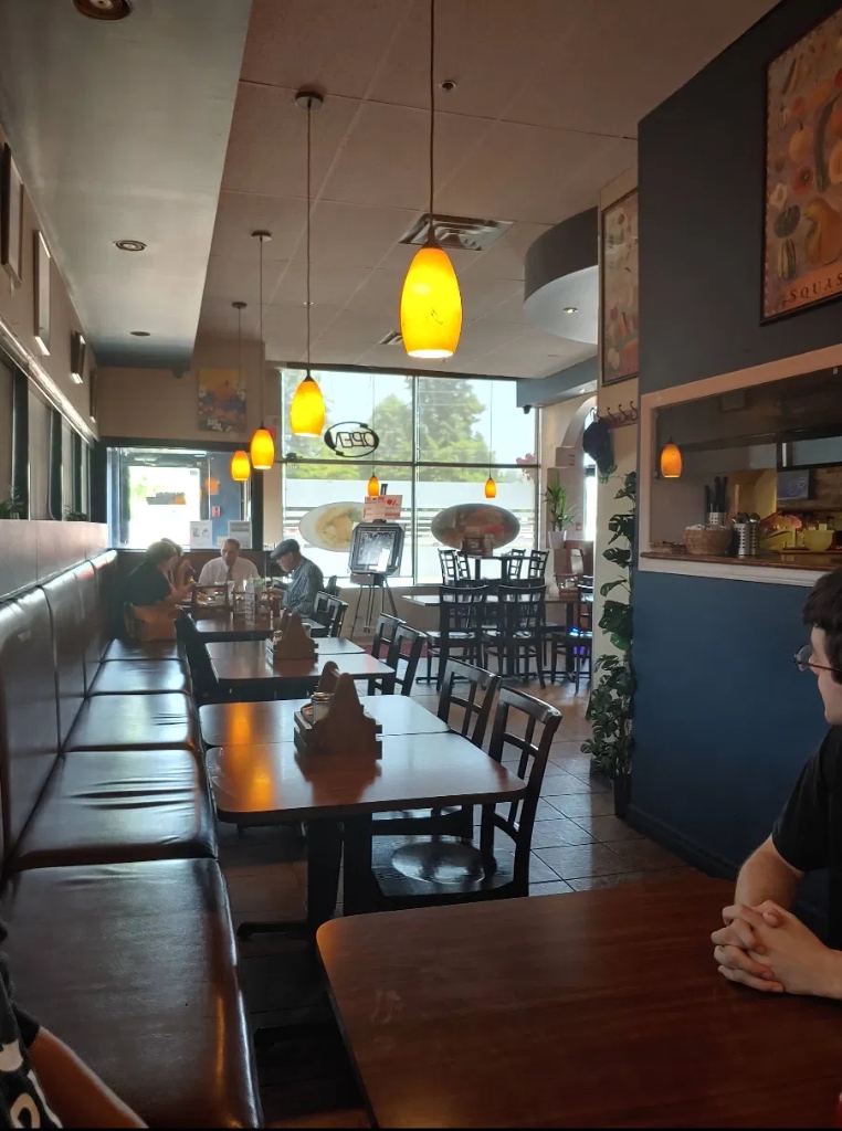 Warm interior of Westney's Restaurant & Bar with cozy leather booths and pendant lights